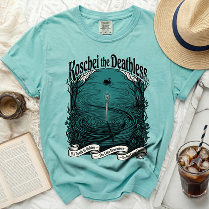 Teal t-shirt with graphic "Koschei the Deathless," black swan, sword, and text.
