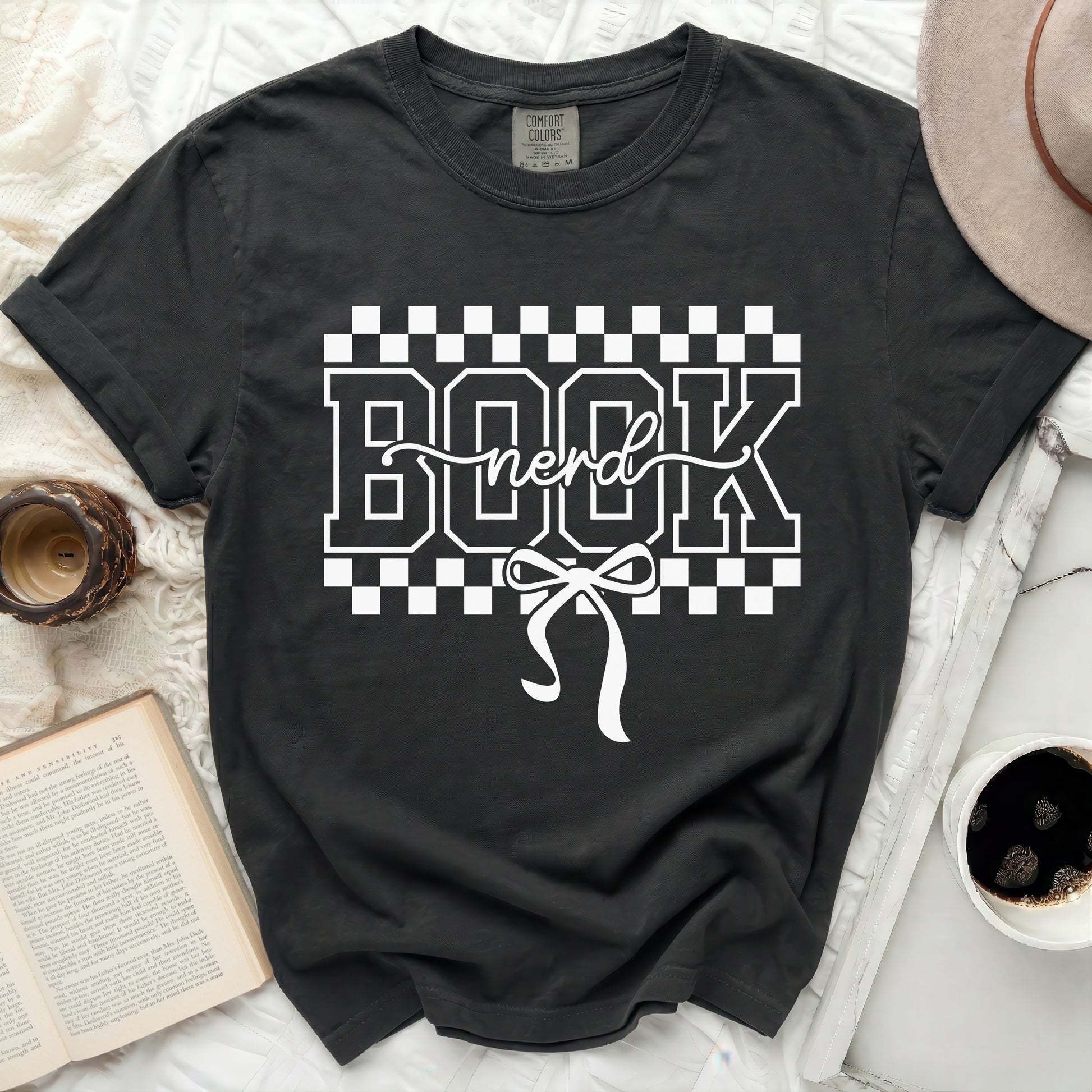 Black t-shirt with white "BOOK nerd" graphic and bow detail.