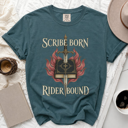 A dark blue t-shirt displays the text "SCRIBE BORN RIDER BOUND" with a book, sword, and flames graphic.