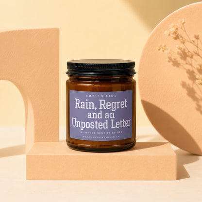 Brown glass candle labeled "Rain, Regret and an Unposted Letter."