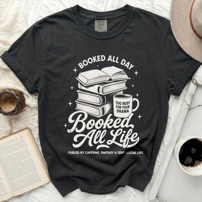 Black t-shirt with white graphic: "Booked All Day," stacked books, mug, and "Booked All Life."