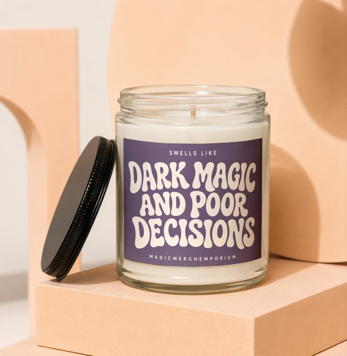 Glass jar candle with purple label reading "Smells Like Dark Magic and Poor Decisions."
