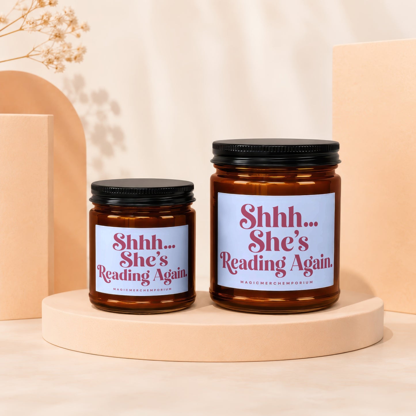 Two amber glass candles with "Shhh... She's Reading Again" text on labels.