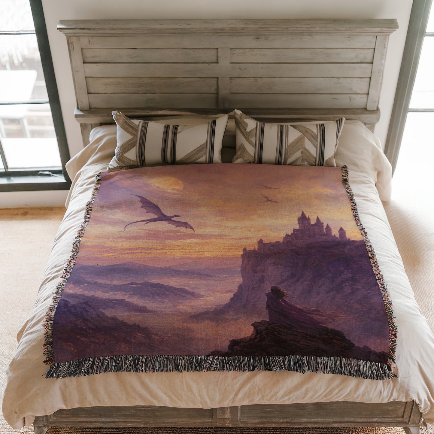 a bedroom with a bed covered in a blanket that depicts a castle and a dragon flying over a mountainous landscape.