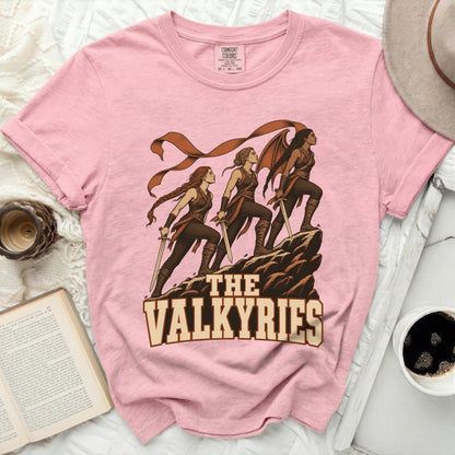 Pink t-shirt with "The Valkyries" graphic of three women with swords on a rocky outcrop.