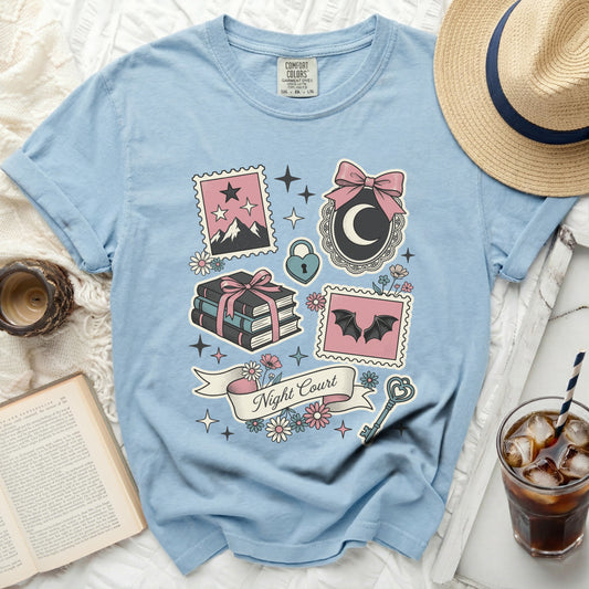 Light blue t-shirt with "Night Court" graphic and fantasy illustrations.