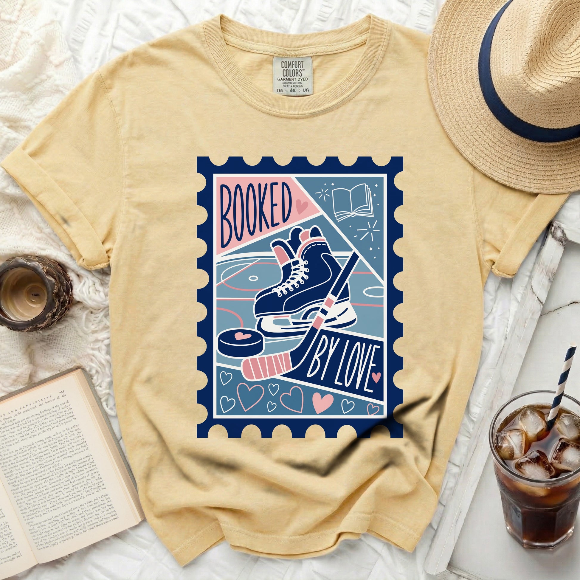 Yellow t-shirt with "BOOKED BY LOVE" ice skating stamp graphic.