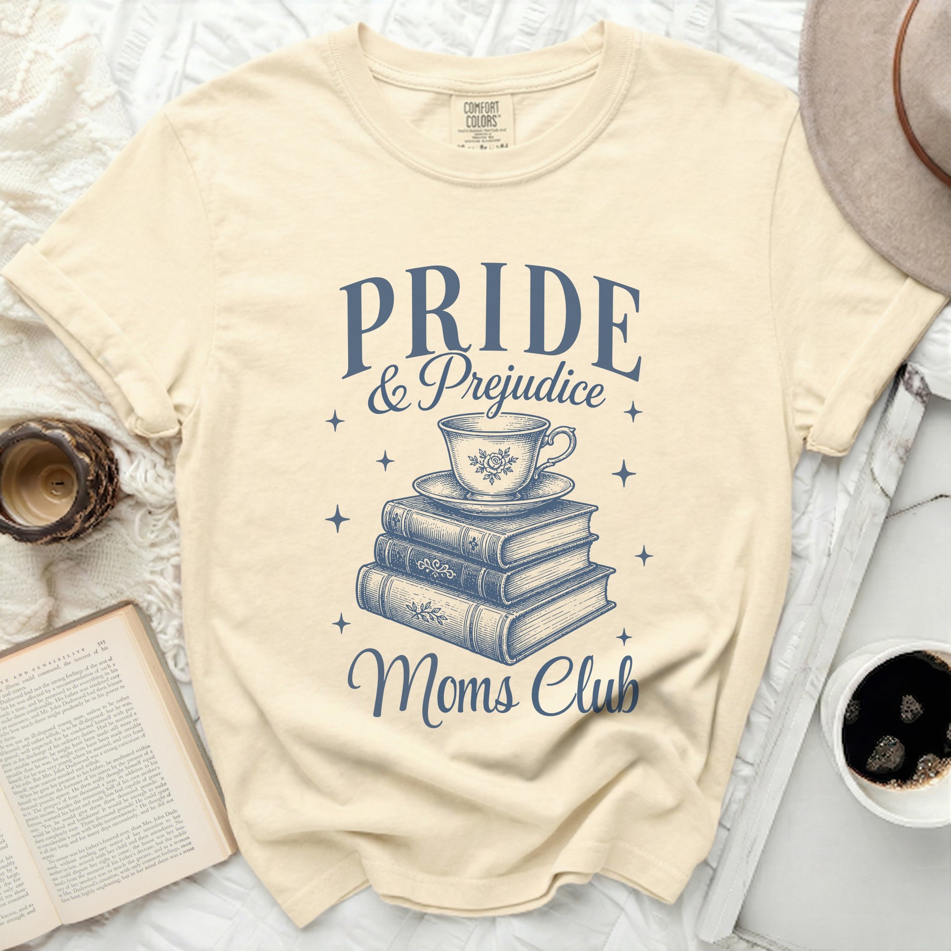 Pride & Prejudice Moms Club graphic on a cream t-shirt.