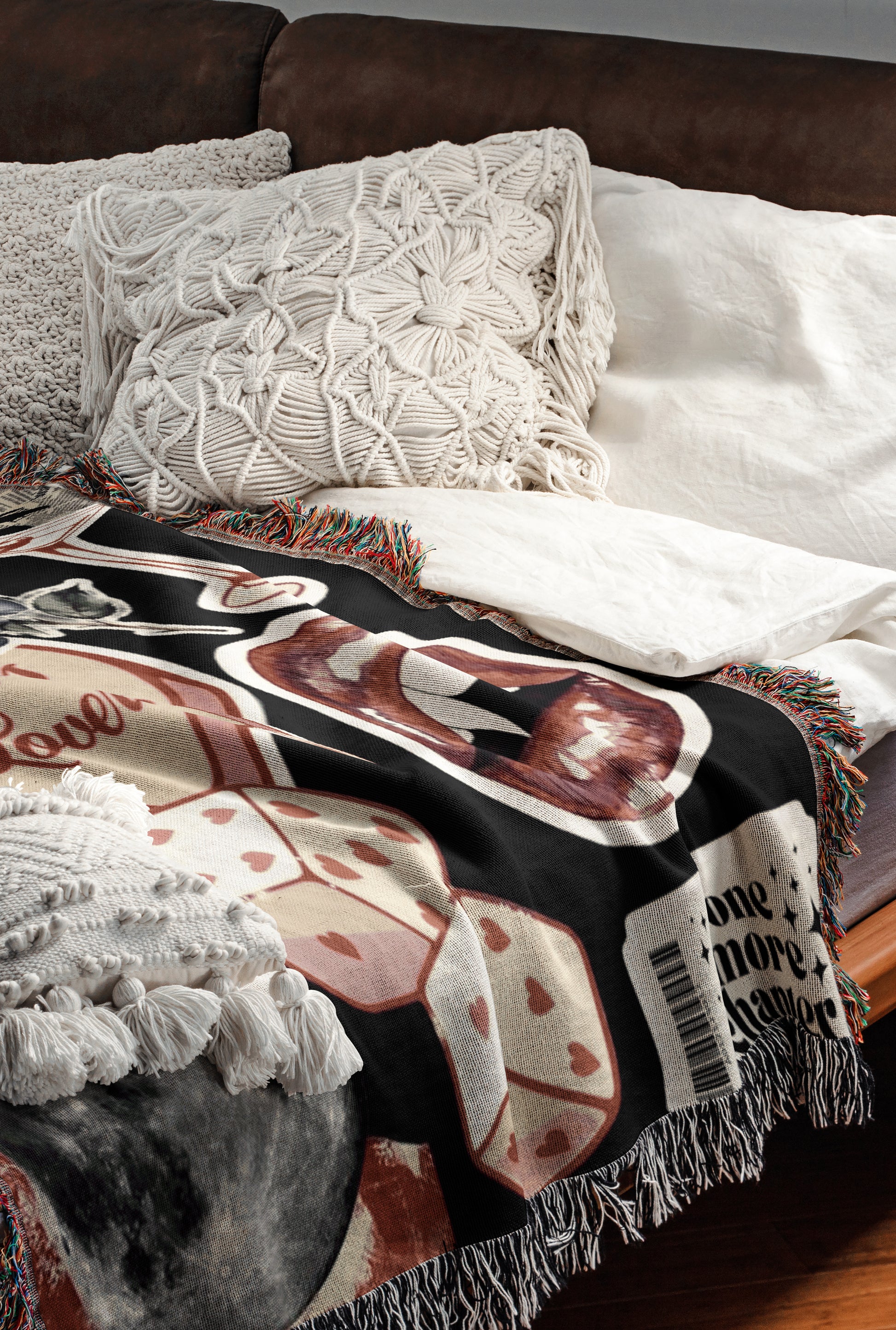 a cozy and inviting bedroom scene, featuring a bed with a black and white patterned blanket and a white pillow. The bed is positioned against a brown leather headboard, creating a warm and comfortable atmosphere.
