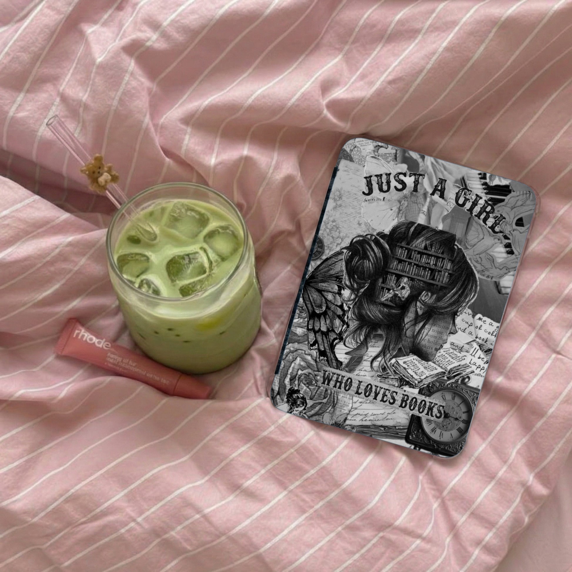 Phone case with "Just a Girl Who Loves Books" text and a glass of iced matcha latte.