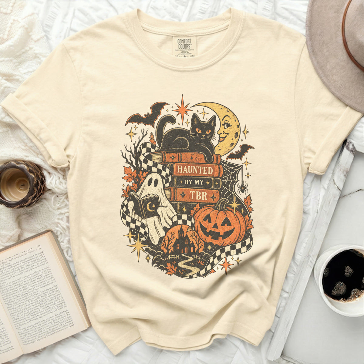 T-shirt with a black cat, ghost, pumpkin, and moon Halloween graphic.
