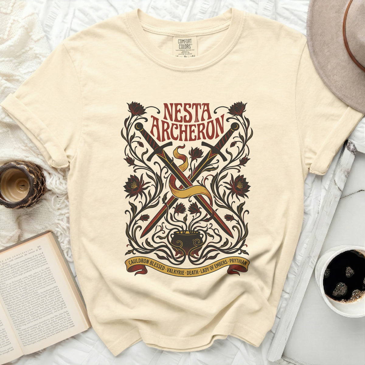 Cream t-shirt with "NESTA ARCHERON" and crossed swords design.