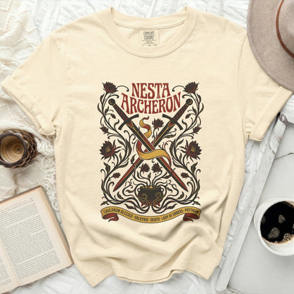 Cream t-shirt with "NESTA ARCHERON" and crossed swords design.