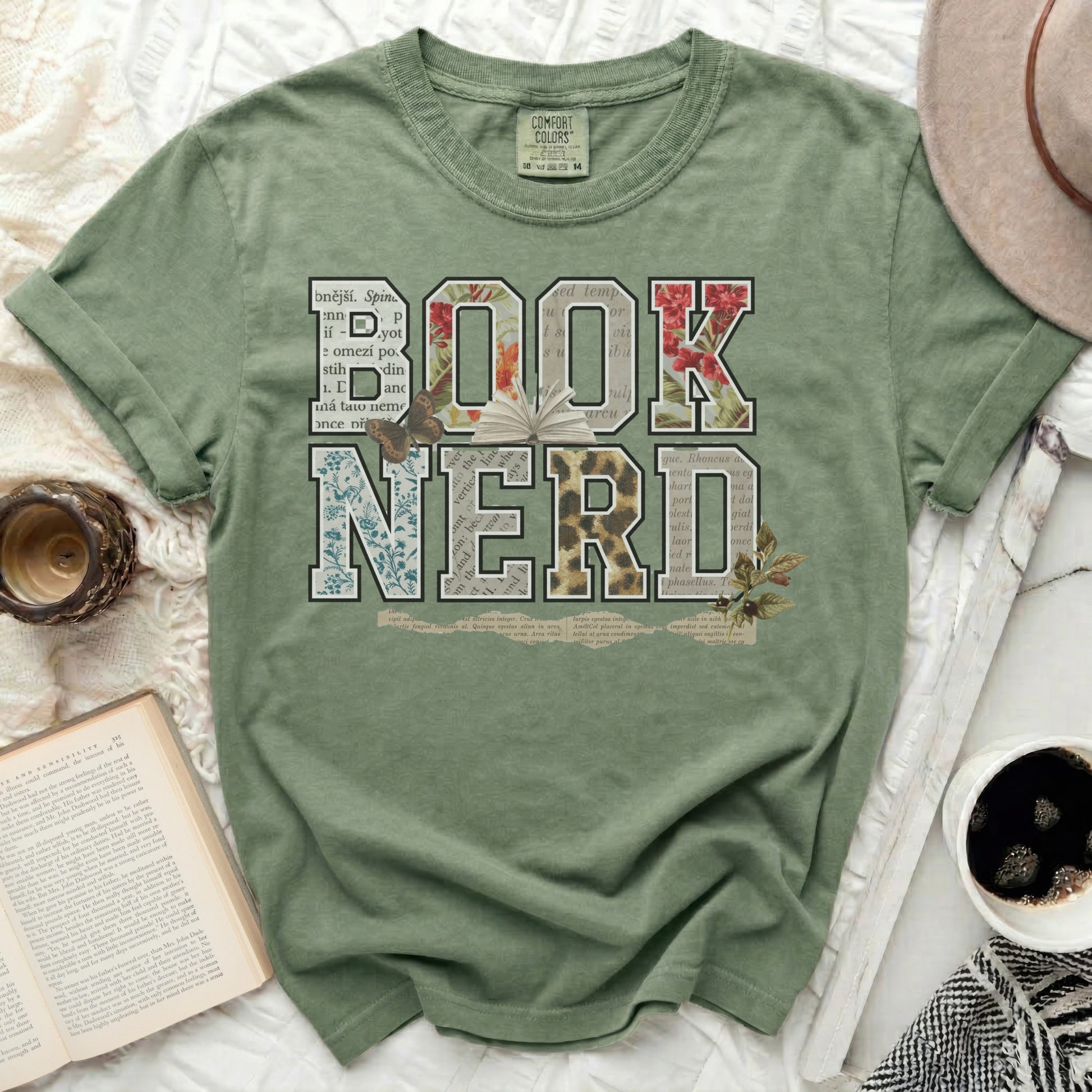 Green t-shirt with "BOOK NERD" in floral and newspaper-style letters.