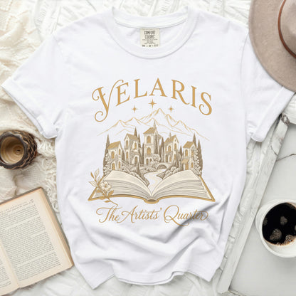 White t-shirt with gold text "Velaris The Artists' Quarter" over an open book design.