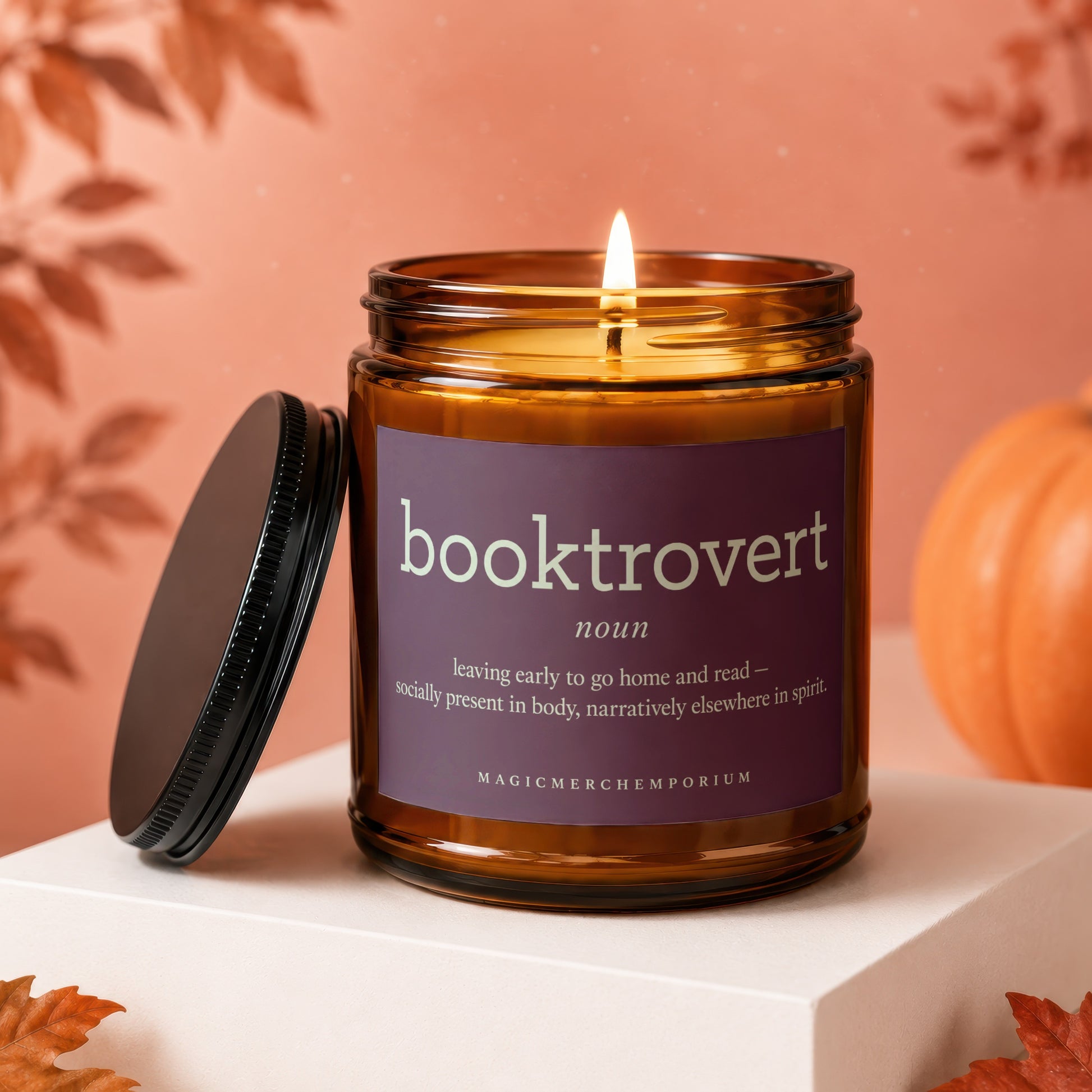 Amber jar candle with "booktrovert" definition and "MagicMerchEmporium" logo.