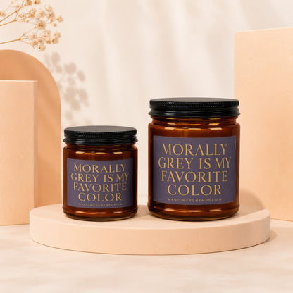 Two amber glass candles with black lids and "Morally Grey Is My Favorite Color" labels.