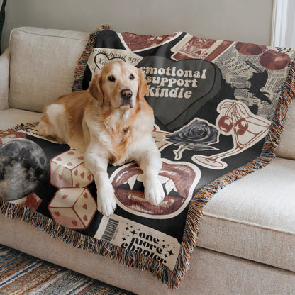A golden retriever dog is lying on a couch with a colorful, patterned blanket featuring various images and text.