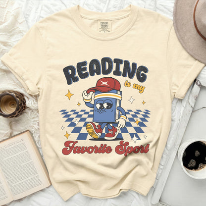 Cream t-shirt with "Reading is my favorite sport" graphic of a walking book.