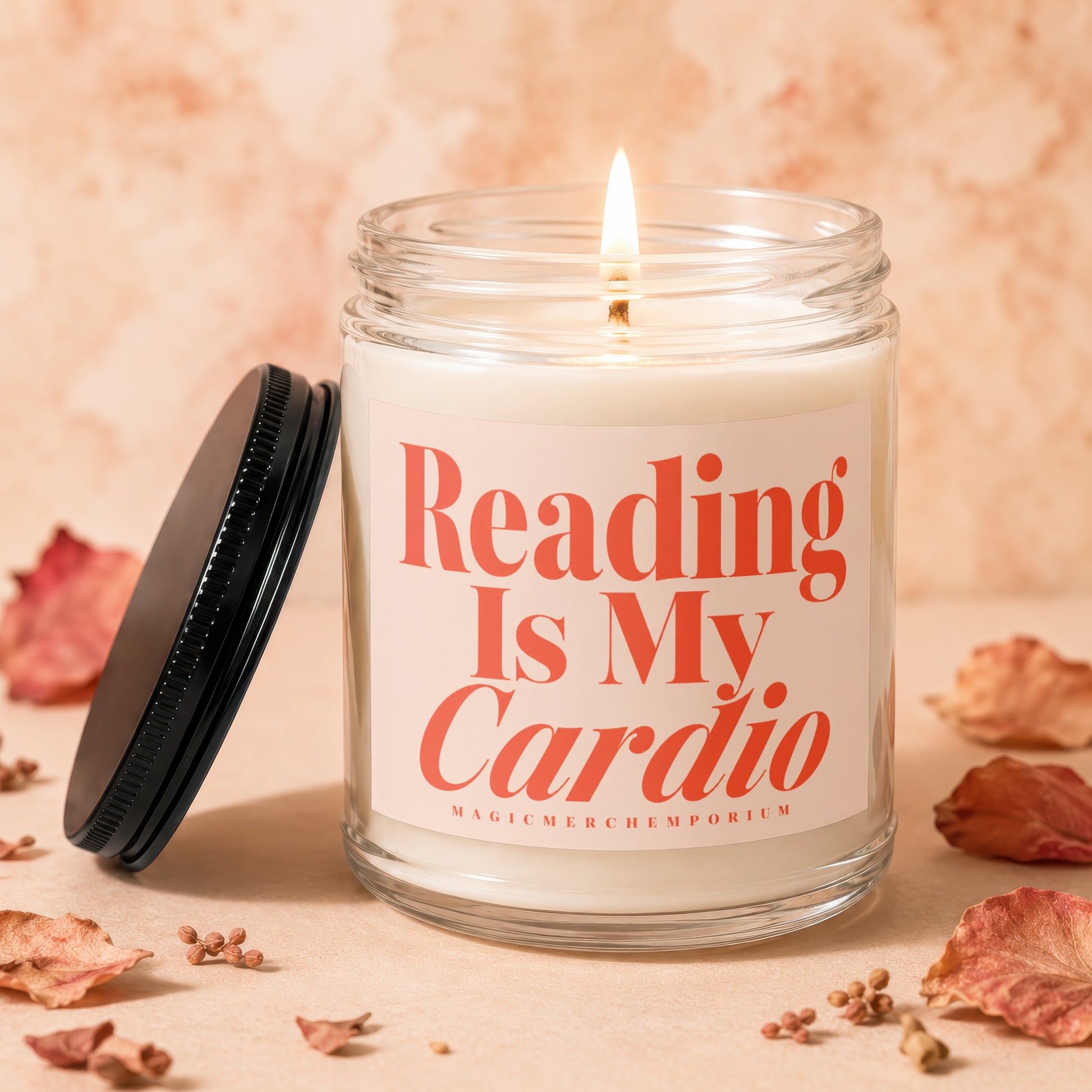 Glass jar candle with lit wick and coral text reading "Reading Is My Cardio".