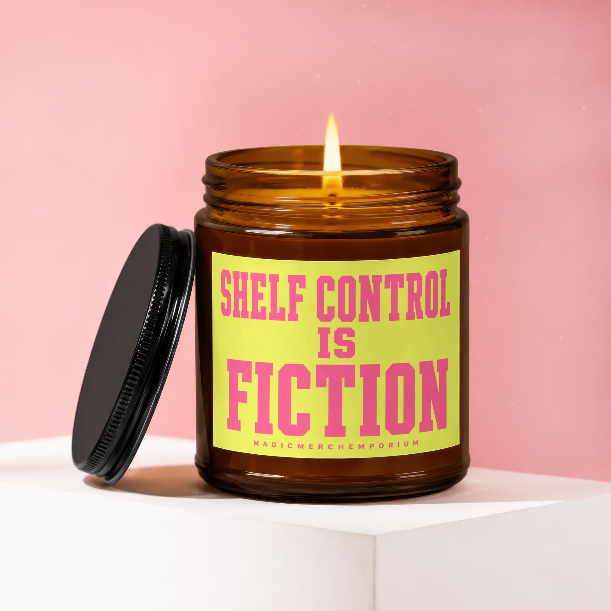 Brown glass candle with lid off, burning wick, and text "Shelf Control Is Fiction".