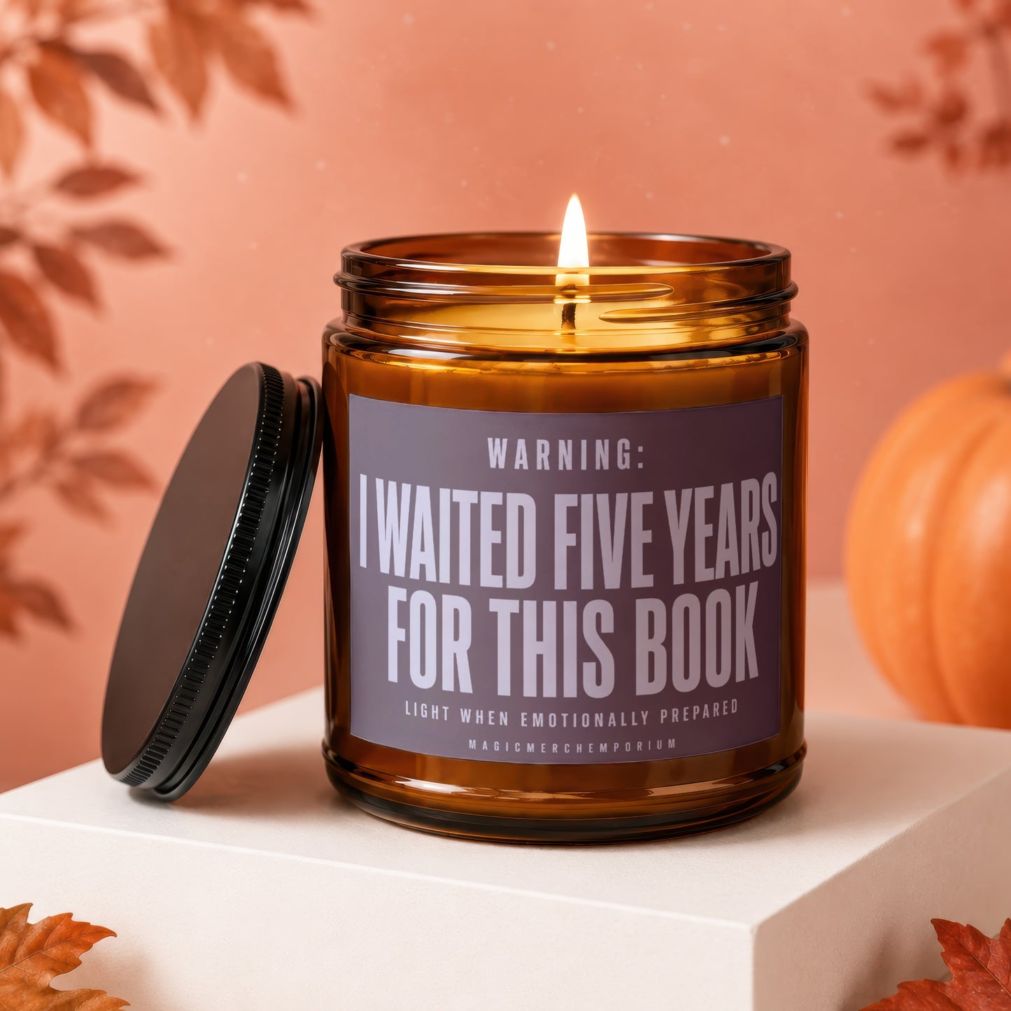 Amber glass candle with lid off, reads "WARNING: I WAITED FIVE YEARS FOR THIS BOOK".