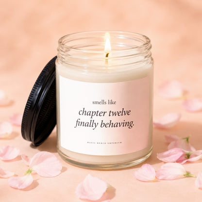 Lit candle in glass jar with lid off, reads "smells like chapter twelve finally behaving."