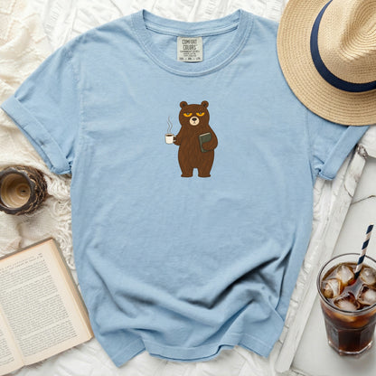 Light blue t-shirt with grumpy bear holding coffee and book graphic.