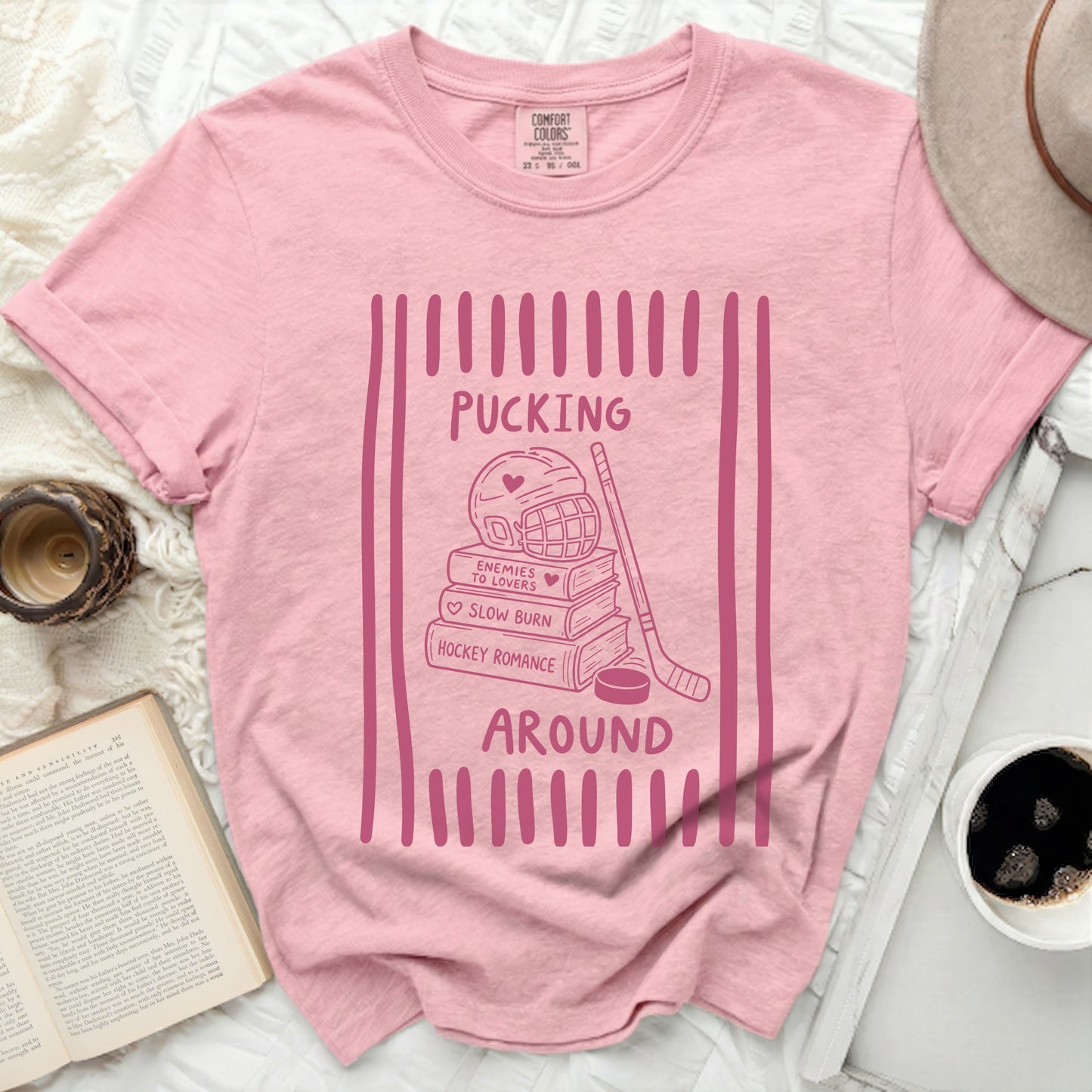 Pink t-shirt with "Pucking Around" hockey romance graphic.