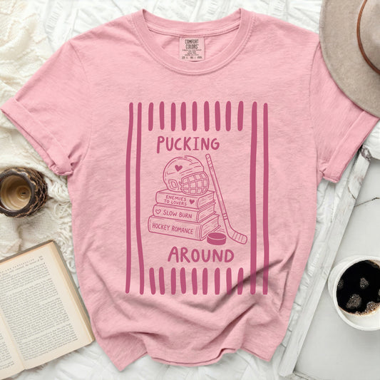 Pink t-shirt with "Pucking Around" hockey romance graphic.