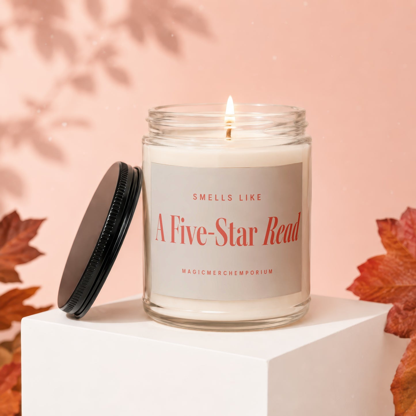 Candle with label "Smells Like A Five-Star Read" on a white block.
