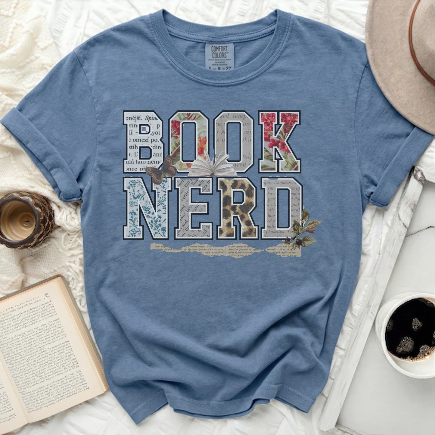 Blue t-shirt with "BOOK NERD" text featuring floral and animal designs.