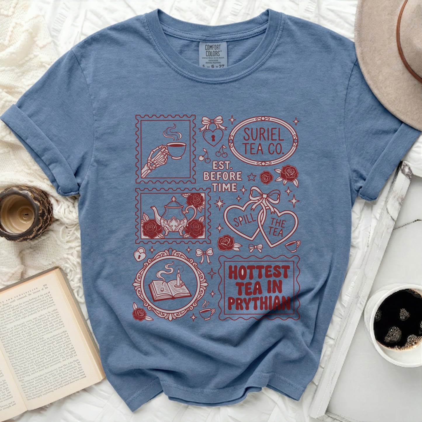 Blue t-shirt with "Suriel Tea Co." and tea-themed graphics.