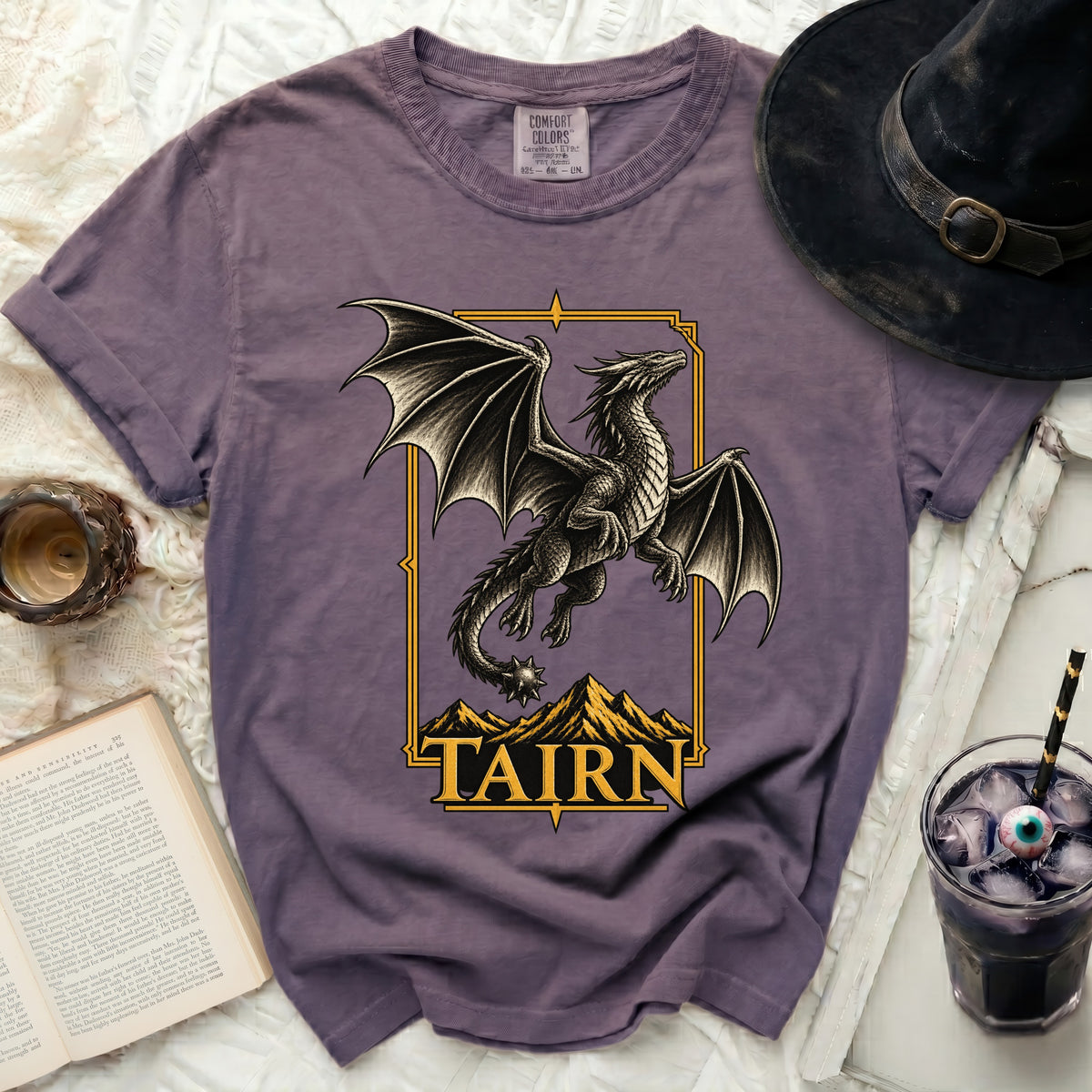Purple t-shirt with a black dragon above mountains and the text "TAIRN".
