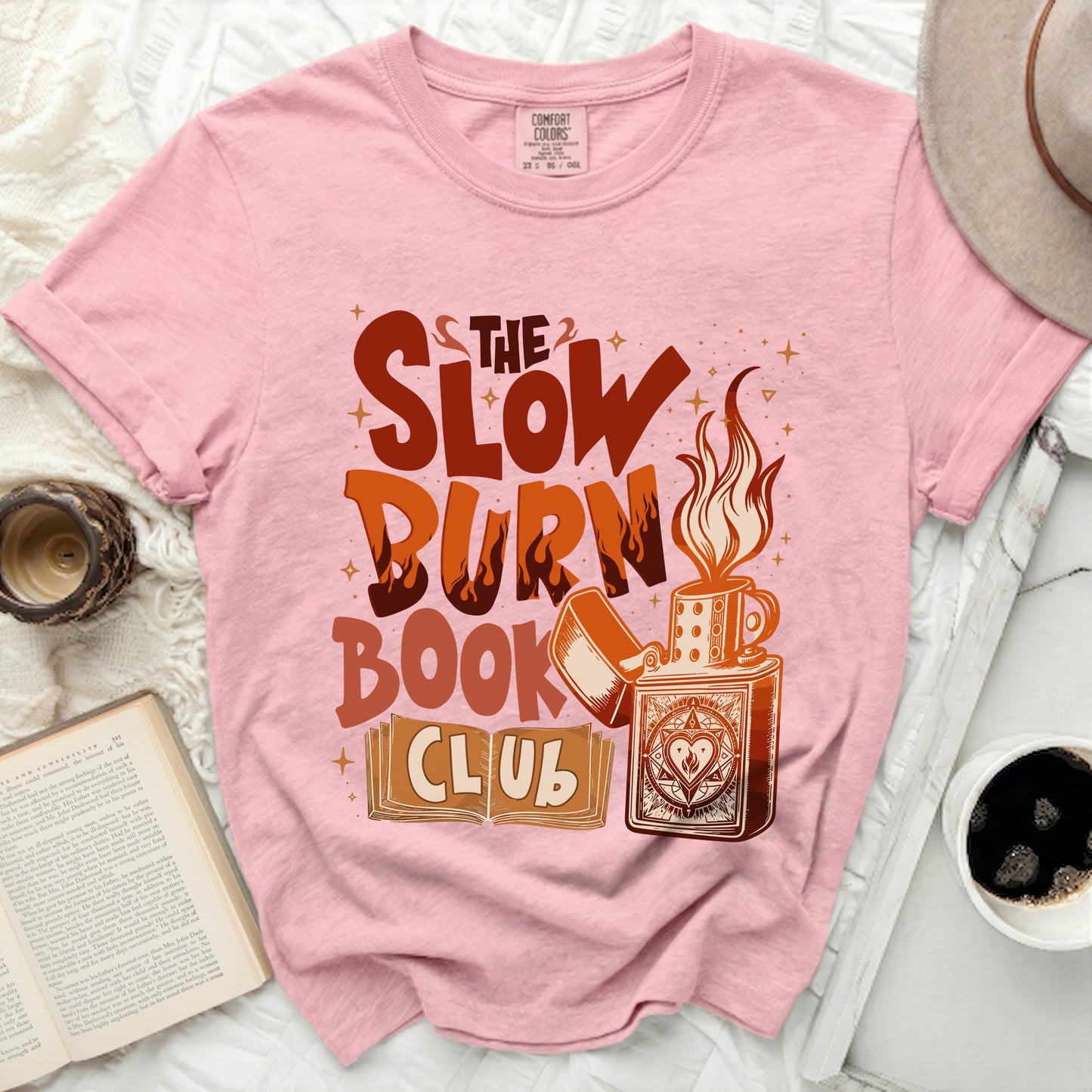 Pink t-shirt with "The Slow Burn Book Club" graphic and a lighter.
