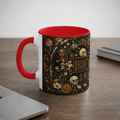 White mug with red accent featuring stained glass art of skulls, books, and flowers.