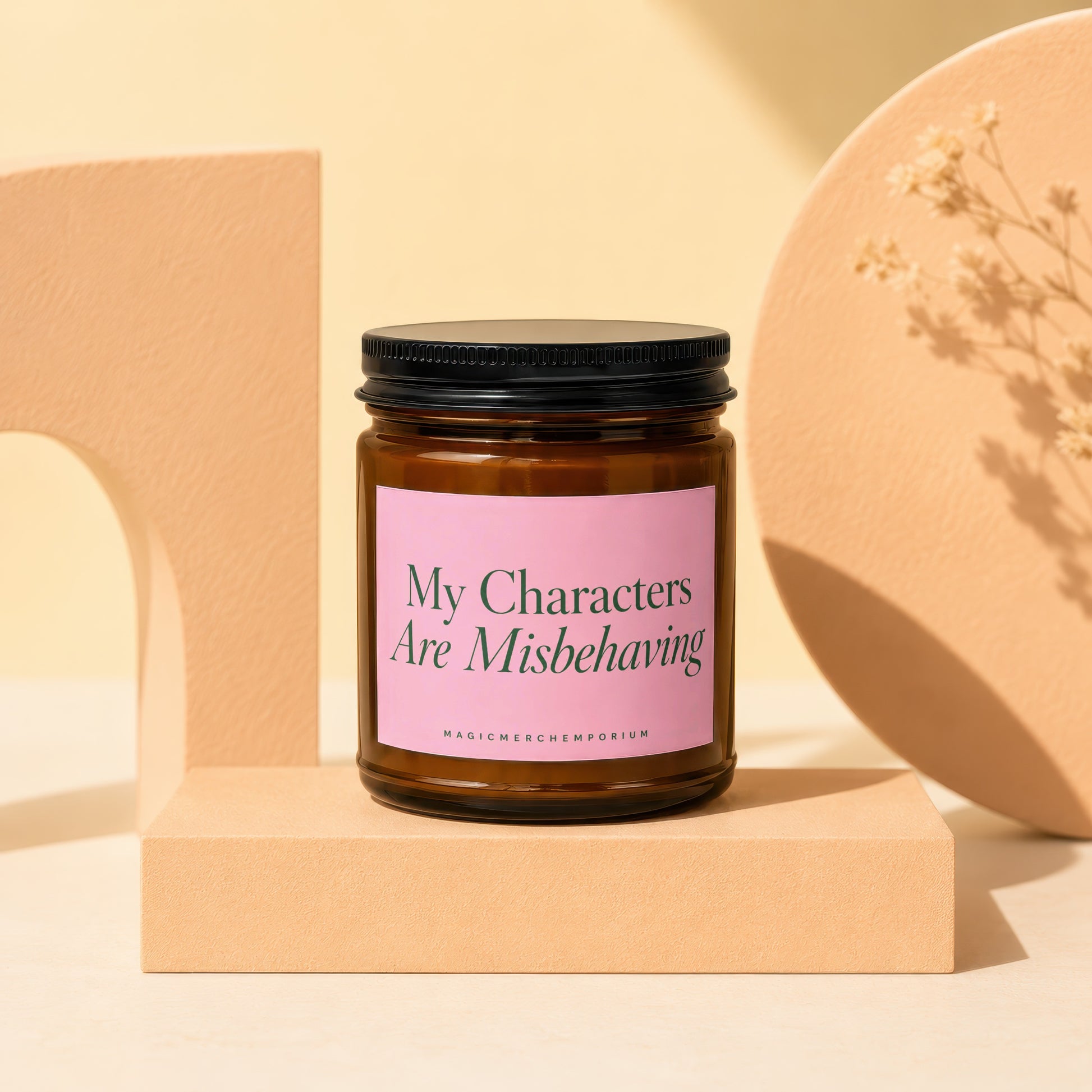 Brown glass candle with pink label reading "My Characters Are Misbehaving."