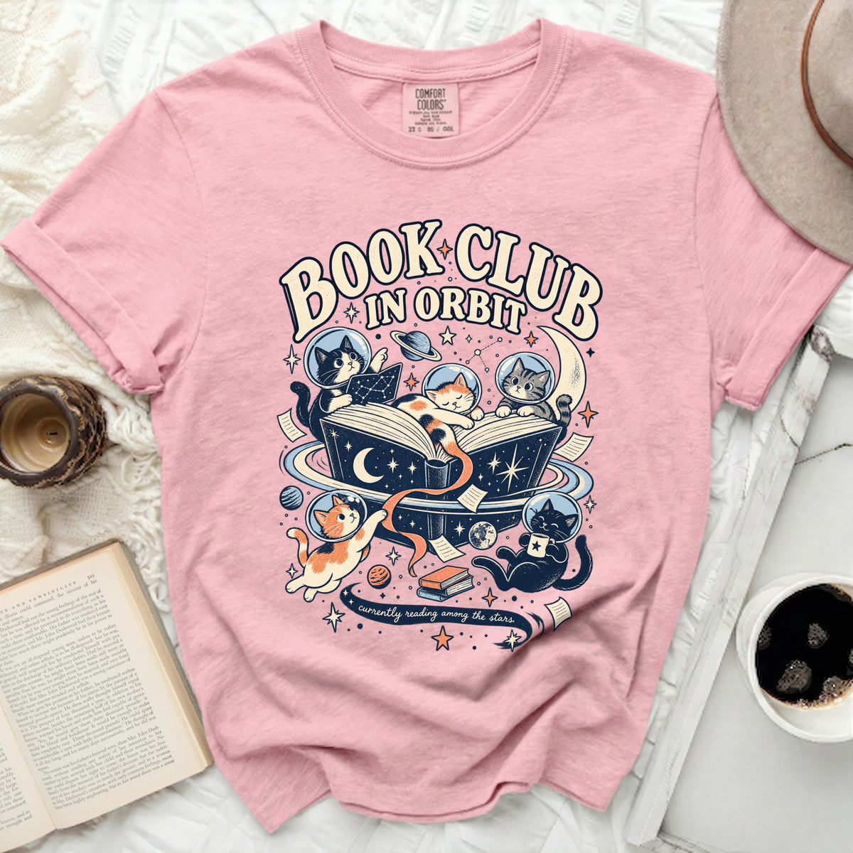 Pink t-shirt with "Book Club in Orbit" text and cats reading in space.