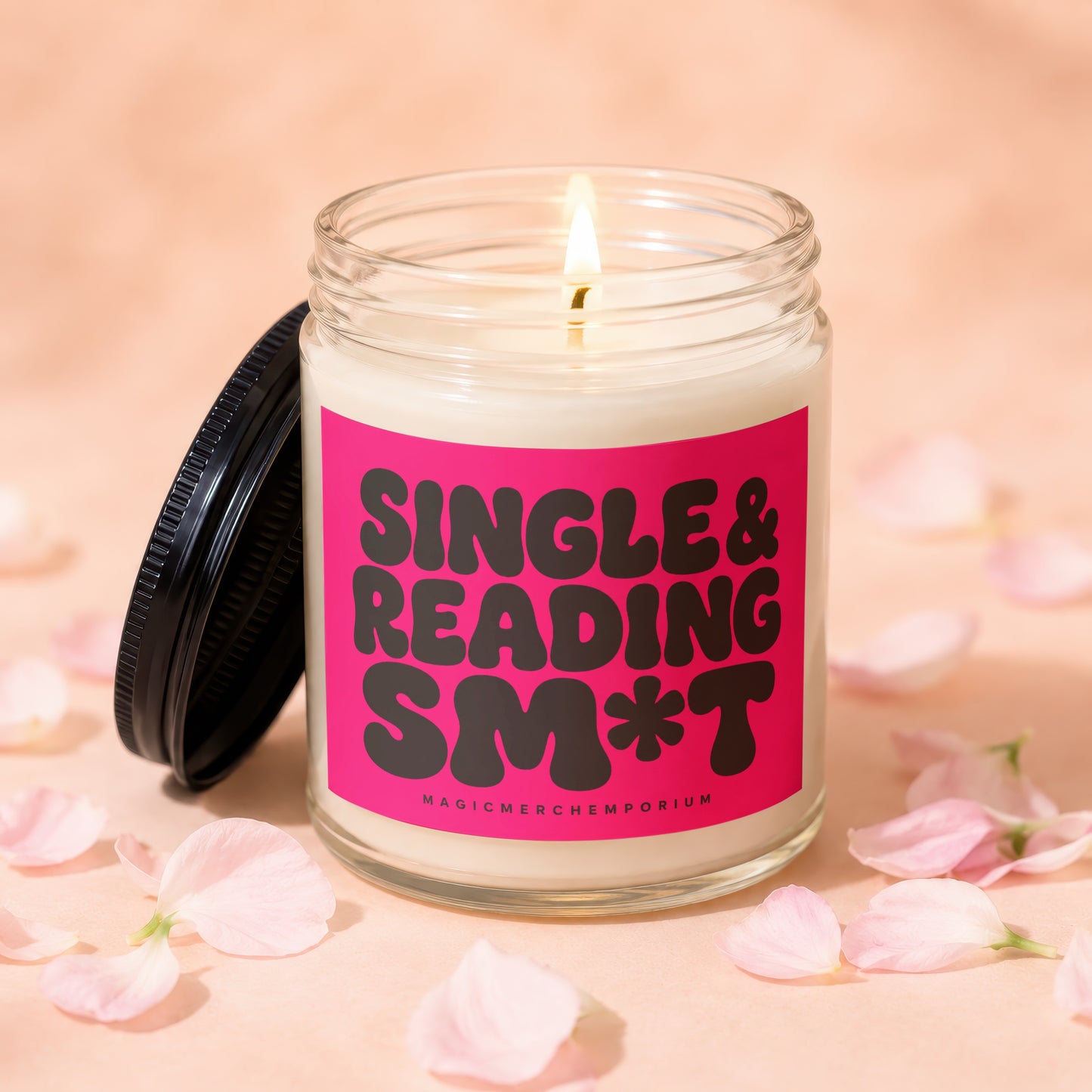 Candle with pink label reading "SINGLE & READING SM*T" surrounded by petals.