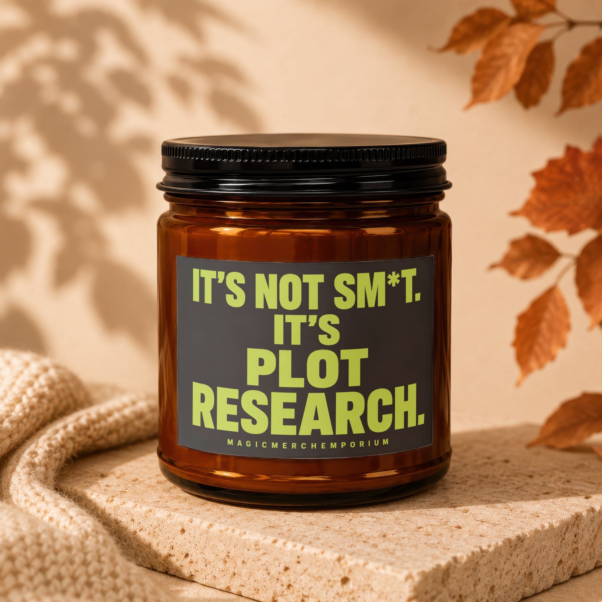 Amber jar candle with black lid reads "It's not sm*t. It's plot research."