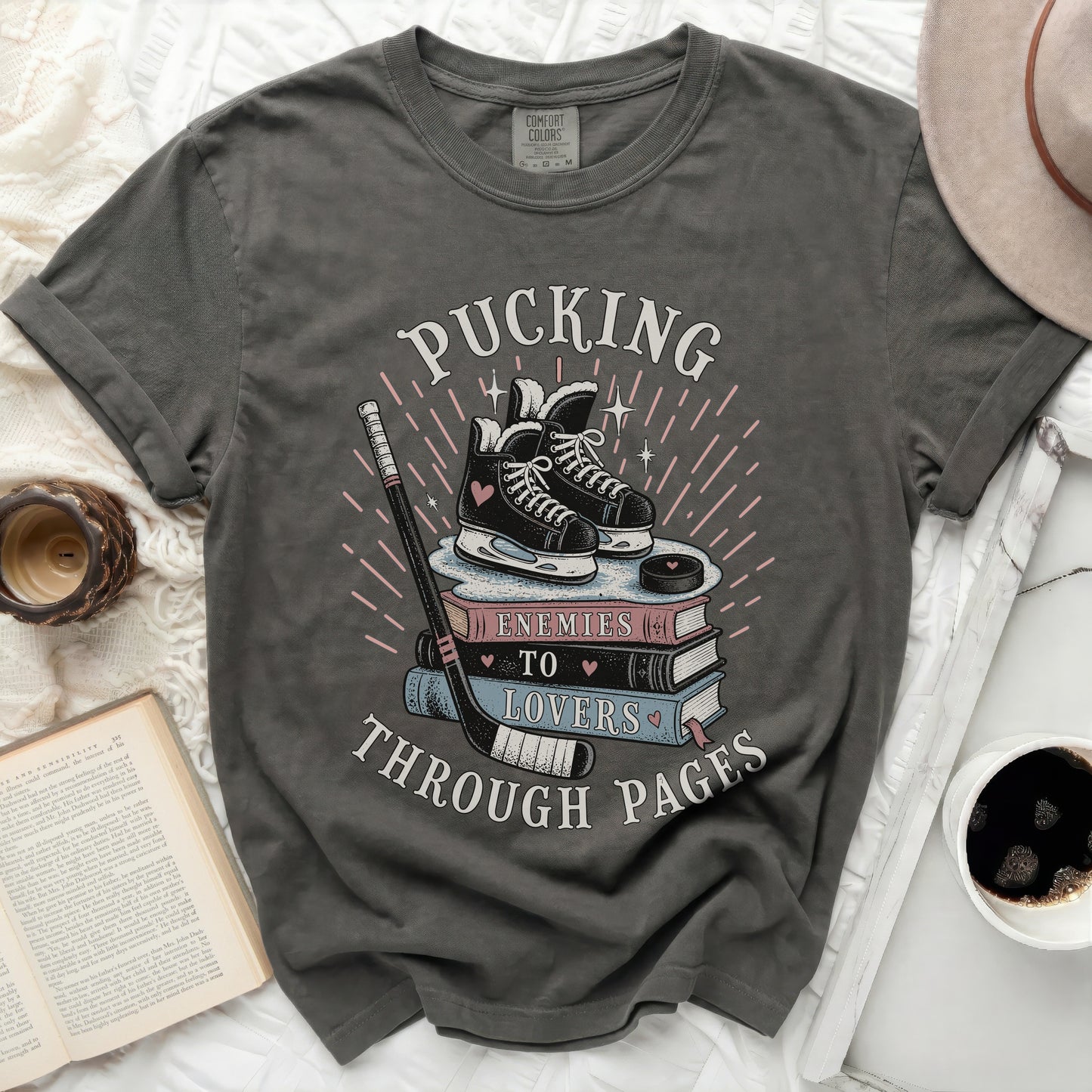 Dark t-shirt with ice skates, hockey stick, and "Pucking Through Pages" text.
