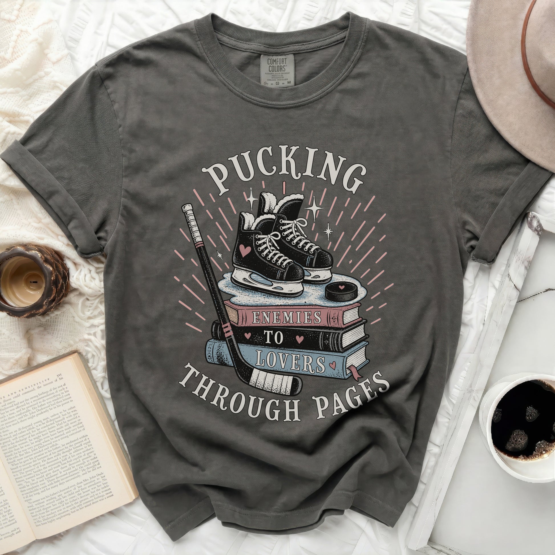 Dark t-shirt with ice skates, hockey stick, and "Pucking Through Pages" text.