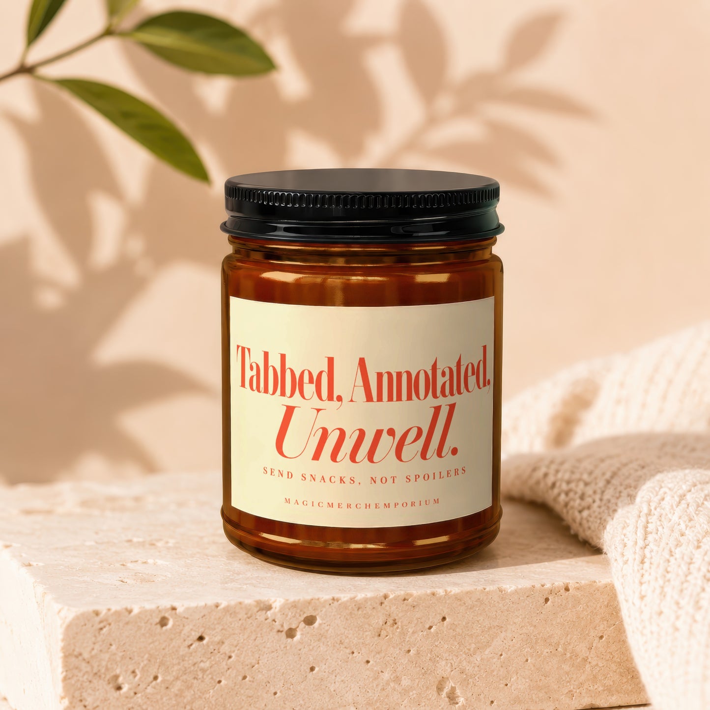 An amber glass jar with a black lid rests on a stone surface beside a folded blanket.