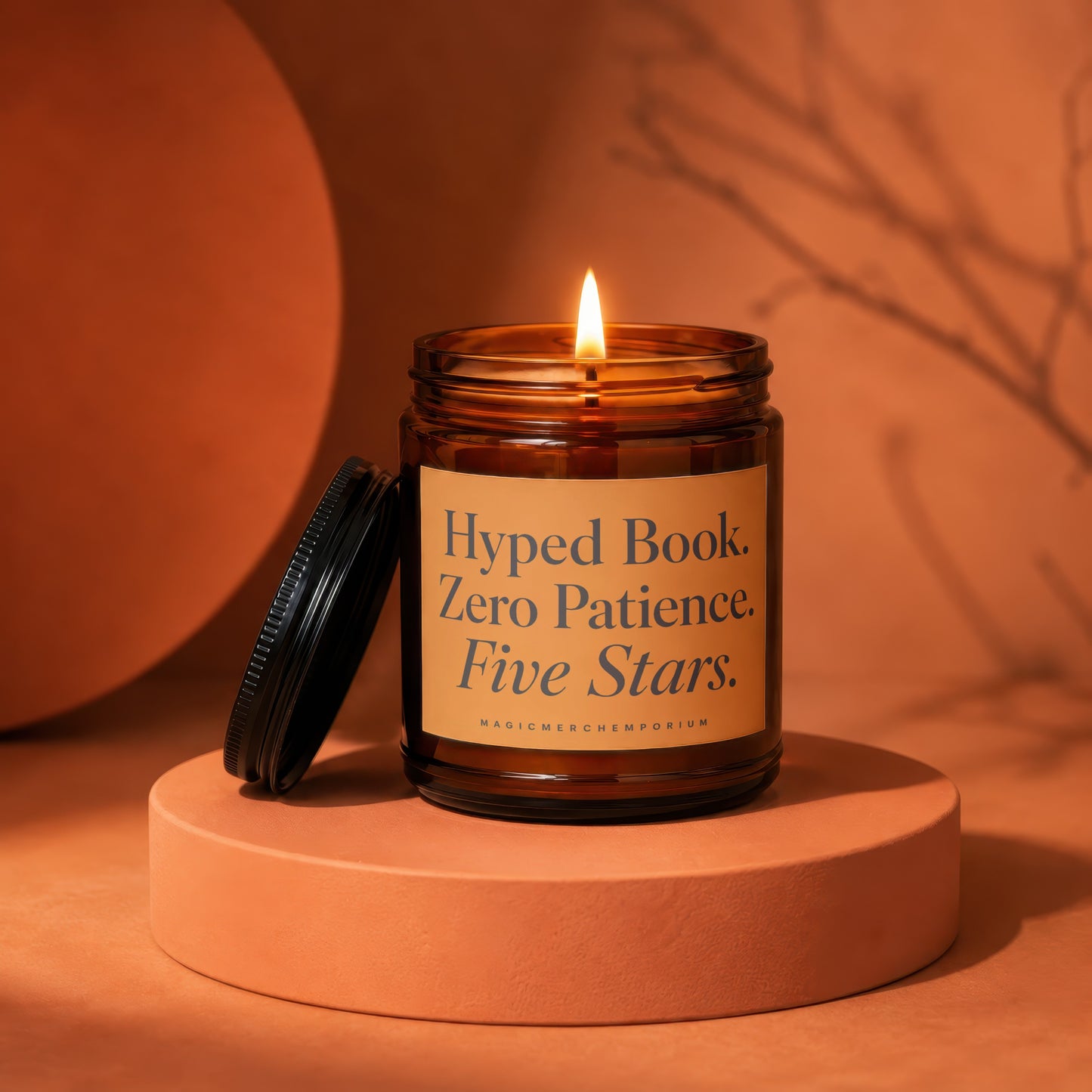 Burning amber candle with lid off, label reads: Hyped Book. Zero Patience. Five Stars.