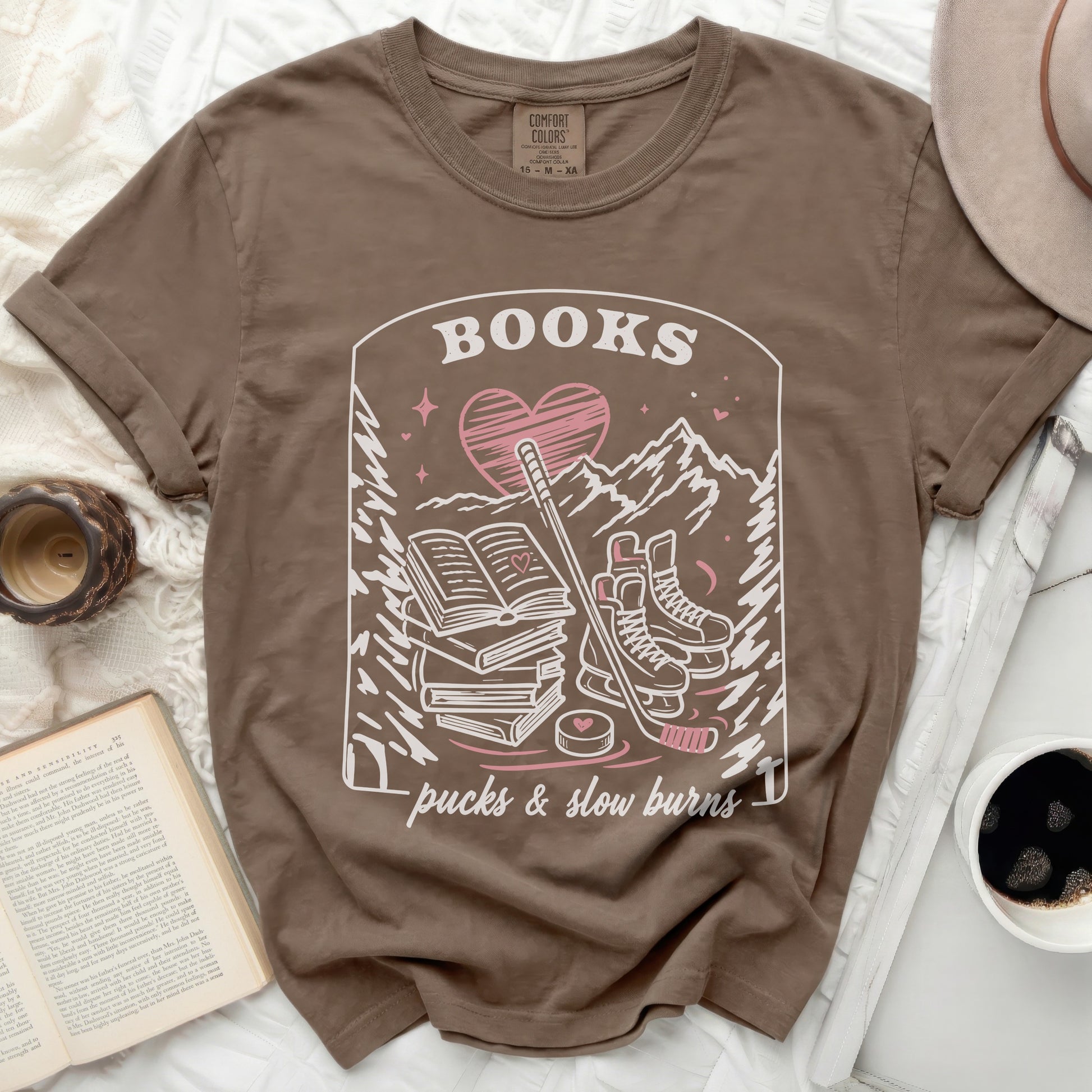 Brown t-shirt with "BOOKS, a heart, hockey sticks, and slow burns" graphic.