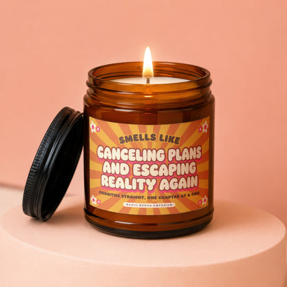 Amber candle with lit wick, "Smells Like Canceling Plans and Escaping Reality Again" text.