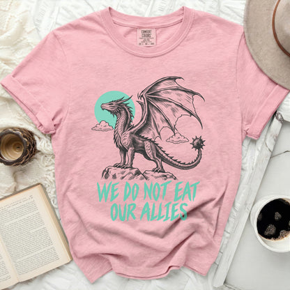 Pink t-shirt with a dragon graphic and text "WE DO NOT EAT OUR ALLIES".