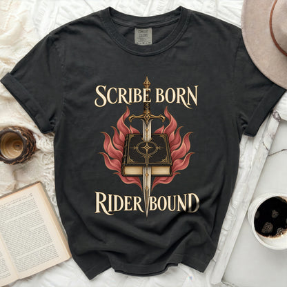 Black Comfort Colors t-shirt featuring the text Scribe Born Rider Bound surrounding an illustration of a sword piercing a book amid red flames.