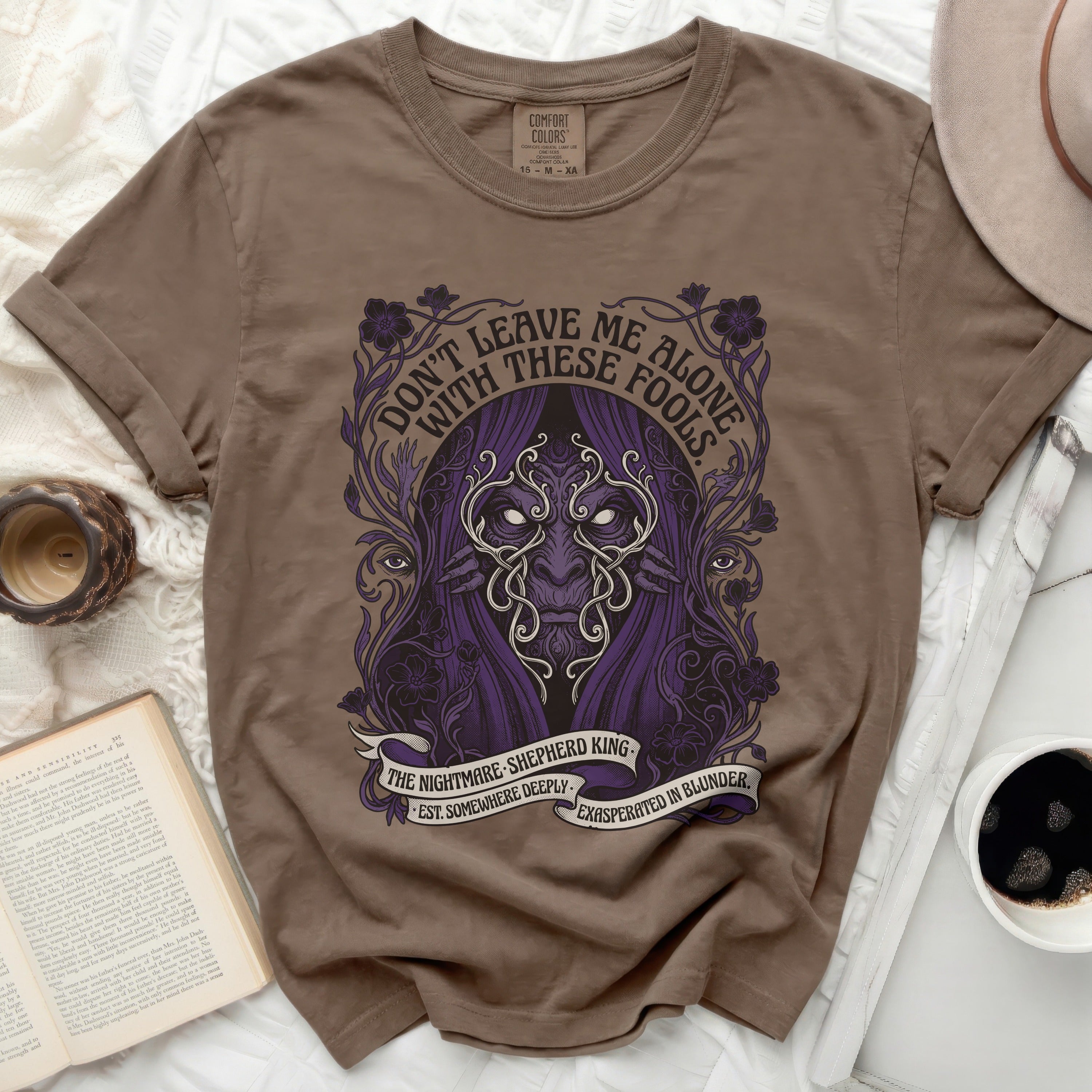 Brown t-shirt with purple graphic of a masked figure and text 