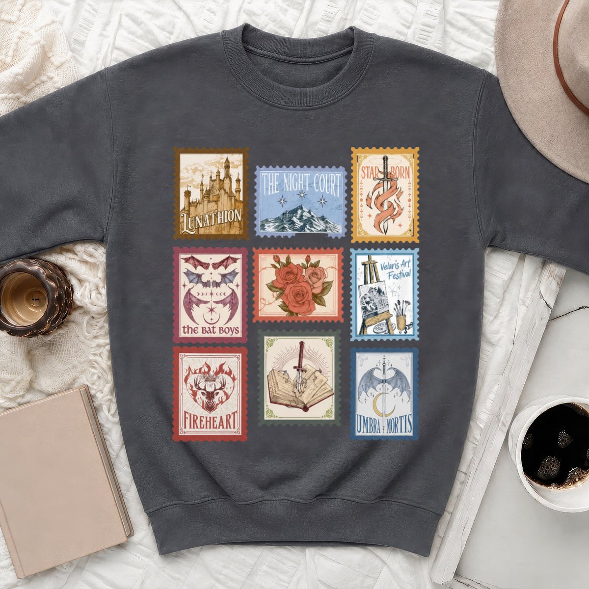 Dark grey sweatshirt with nine postage stamp designs, featuring castles, mountains, swords, and dragons.